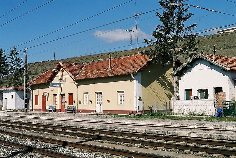 Edificio de una estación de tren de un lugar pequeño. Delante se aprecian las vías