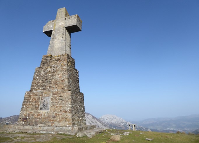 Una cruz de piedra grande en la cima de un monte